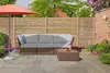 An outdoor patio scene with a sectional sofa, coffee table, and umbrella. Produktbild-Vorschau
