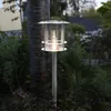 A solar-powered path light is illuminated in a garden setting. Produktbild-Vorschau