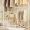 A white telescoping garment rack with clothes and accessories displayed on shelves and hanging rods. Produktbild-Vorschau