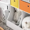 A close-up view of a white storage unit with colorful fabric boxes and stuffed animals. Anteprima dell’immagine prodotto