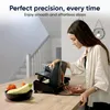 A woman is using a slicer in a kitchen. Anteprima dell’immagine prodotto