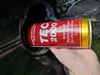 A hand is holding a can of diesel system cleaner and pouring it into a car's fuel tank. Produktbild-Vorschau