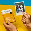 A person holds a Polaroid photo and a box of Polaroid film. Voir les images du produit