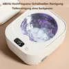 A close-up product shot of a white ultrasonic cleaner with water and purple light inside, set against a soft, textured background. Produktbild-Vorschau