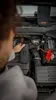 A person is using a jump starter to start a car. Náhled obrázku produktu