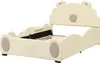A cream-colored children's bed with a playful design, featuring rounded edges and decorative elements resembling ears and a face. The bed is shown from a slightly elevated side angle against a plain white background. Podgląd zdjęcia produktu
