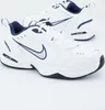 A pair of white Nike Air Monarch IV sneakers with navy blue accents, shown from a slightly angled front view on a white background. Produktbild-Vorschau
