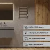 A bathroom setting with a sink, mirror, and a towel warmer. Produktbild-Vorschau