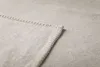 A close-up view of the corner of a light gray blanket, showing the stitching along the edge. Produktbild-Vorschau