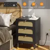 A bedside table with drawers and integrated power outlets, next to a bed. Voir les images du produit
