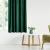 A dark green velvet curtain hangs next to a window, with a small white table and a green armchair in the foreground. Produktbild-Vorschau