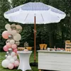An outdoor party setup with a striped umbrella, balloon arch, and dessert bar. Produktbild-Vorschau