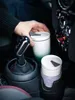 A hand is placing a coffee cup into a car's cup holder. Voir les images du produit