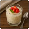 A glass of tapioca pudding topped with strawberries and mint, with a spoon and napkin in the background. Produktbild-Vorschau