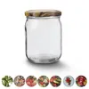 A clear glass jar with a decorative lid sits on a white background. Below the jar are several circular images of various preserved foods. Produktbild-Vorschau