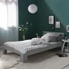 A modern bedroom with a gray wooden bed, white and black patterned bedding, and a dark green accent wall. Náhled obrázku produktu