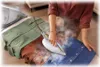 A person is ironing clothes on an ironing board with a steam iron. Voir les images du produit