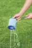 A person is cleaning a pool filter cartridge with a garden hose on a grassy lawn. Produktbild-Vorschau