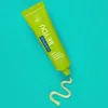 A tube of green toothpaste with a swirl of toothpaste coming out of the nozzle, set against a turquoise background. Anteprima dell’immagine prodotto