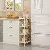 A kitchen scene with a white shelving unit next to a refrigerator and cabinets. Produktbild-Vorschau