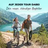 A couple cycling and walking on a mountain path with a lake and mountains in the background. Voir les images du produit