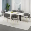 A dining room set with a marble-top table and six gray chairs with gold legs. Produktbild-Vorschau