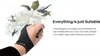A hand wearing a black artist's glove is holding a stylus, with a watercolor painting of flowers in the background. Produktbild-Vorschau