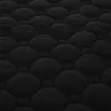 A close-up, textured view of a black quilted fabric with a hexagonal pattern. Náhľad obrázku produktu