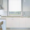 A clean, modern kitchen with white cabinets and a window with white blinds. Produktbild-Vorschau
