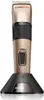 A gold and black hair clipper is shown standing upright on its black charging base against a white background. Produktbild-Vorschau
