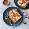A slice of marble cake with chocolate and hazelnuts on a plate. Náhľad obrázku produktu