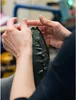 Hands are shown working on the sole of a boot. Produktbild-Vorschau