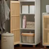 A narrow white cabinet with a wooden slatted door is shown open, revealing shelves with various household items. Voir les images du produit