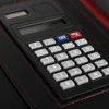 A close-up view of a black and red conference folder with a built-in calculator. Voir les images du produit