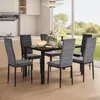 A dining set with chairs and a table in a well-lit room with a large window overlooking a garden. Anteprima dell’immagine prodotto