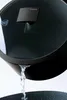 Water is being poured from a pot lid with a steam vent, demonstrating a feature of the cookware. Podgląd zdjęcia produktu