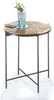A round side table with a woven top and metal legs, featuring a drink and a book on top. Produktbild-Vorschau