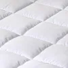 A close-up, angled view of a white quilted mattress topper. Produktbild-Vorschau
