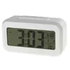 A white digital alarm clock with a large LCD screen displaying the time, alarm, date, and temperature. Náhled obrázku produktu
