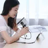 A woman is using a microphone and headphones, connected to a smartphone on a stand, likely for recording or streaming. Anteprima dell’immagine prodotto