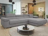 A modern living room with a gray sectional sofa, a round coffee table with a teapot and cups, and decorative shelves with plants and books. Náhľad obrázku produktu