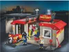 A toy fire station with figures and a motorcycle at dusk. Anteprima dell’immagine prodotto
