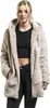A woman wearing a beige sherpa jacket and black jeans, posing against a white background. Produktbild-Vorschau
