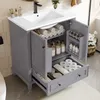 A grey bathroom vanity with a white ceramic sink, open doors revealing storage, and a partially open drawer filled with toiletries. Náhled obrázku produktu