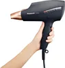 A hand holding a black and rose gold Panasonic hair dryer against a white background. Anteprima dell’immagine prodotto