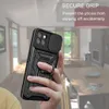 A hand holding a black phone case with a ring stand in a living room. Produktbild-Vorschau