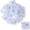 A pile of small white packets of silica gel desiccant. Produktbild-Vorschau