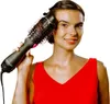 A woman is using a Revlon hair dryer brush on her hair. Podgląd zdjęcia produktu