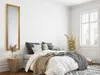 A bedroom scene with a bed, pillows, blankets, a mirror, and a side table. Produktbild-Vorschau