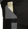 A close-up view of a black work pant pocket with a folding ruler inserted. Produktbild-Vorschau